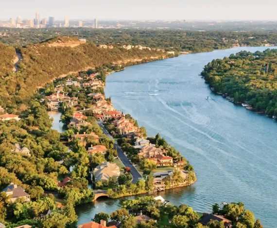 Aerial view of Lake Austin and surrounding homes with Austin skyline in the distance, representing Luna Environmental’s service area in Central Texas