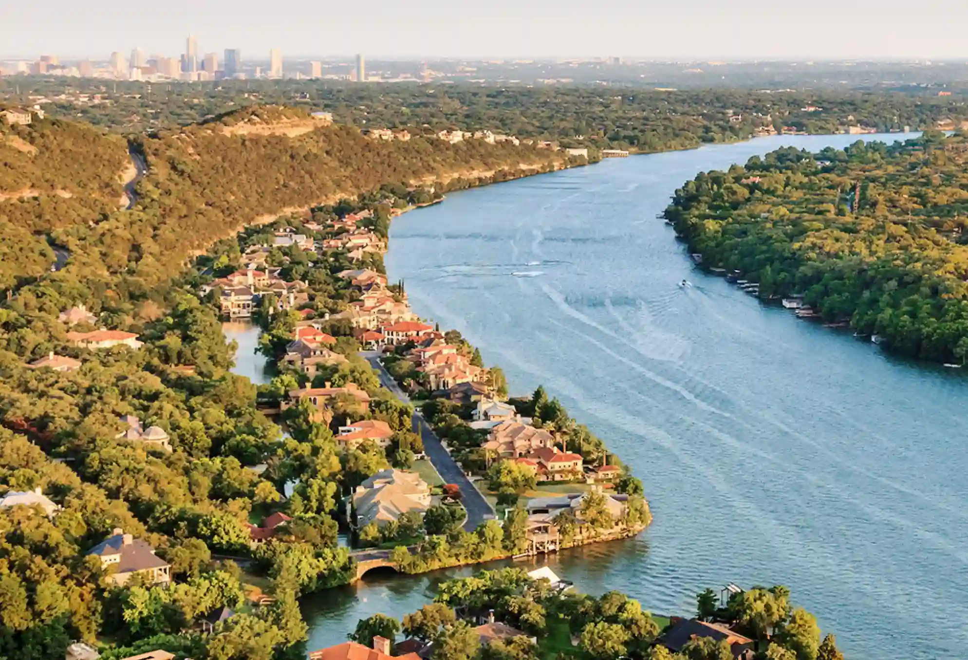 Aerial view of Lake Austin and surrounding homes with Austin skyline in the distance, representing Luna Environmental’s service area in Central Texas