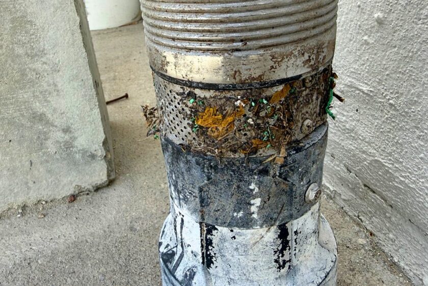 Debris packed into the intake screen band of a septic pump